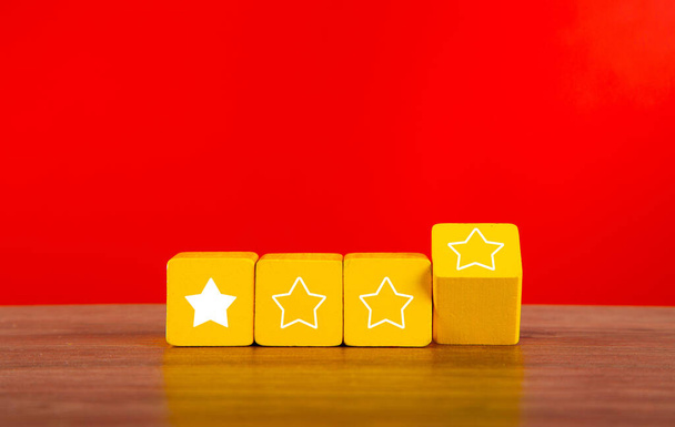 Cubos de madeira com uma estrela em cada quatro. Conceito de má classificação e avaliação dos serviços. - Foto, Imagem