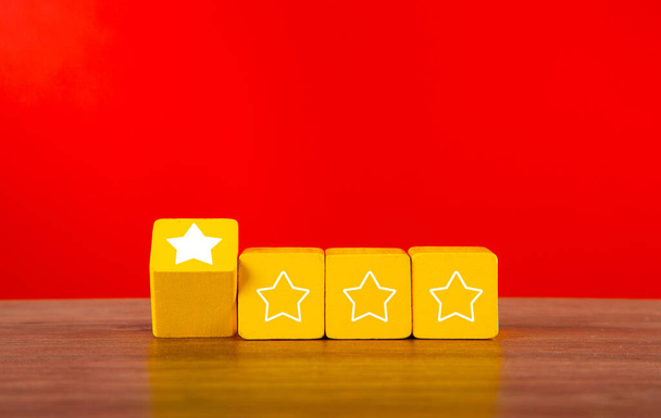 Cubos de madeira com uma estrela em cada quatro. Conceito de má classificação e avaliação dos serviços. - Foto, Imagem