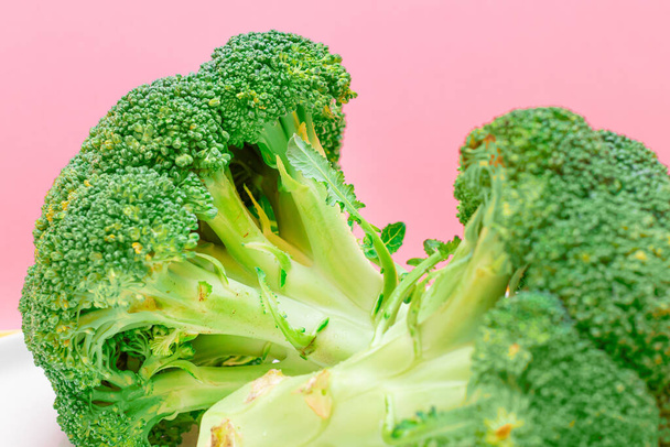 Fresh and Raw Broccoli Against the Pink Background. Uncooked Green Cabbage - 写真・画像