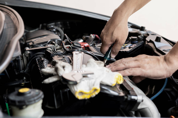 自動車技術者の男性は、エンジンルームサービスとメンテナンスコンセプトでボルトを削除ドライバーを使用します  - 写真・画像