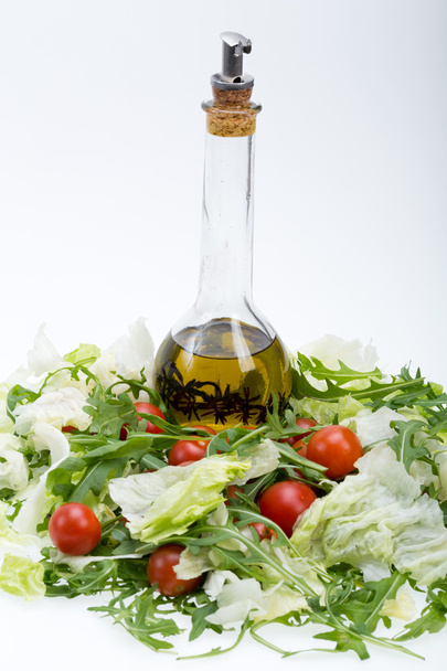Montón de ruccola, lechuga, tomates y aceite de oliva con el tomillo
 - Foto, imagen