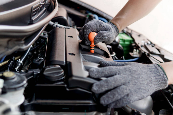 Controllo meccanico del livello dell'olio motore nella sala macchine nel centro di assistenza auto riparazione, foto di servizio per il concetto di business dell'automobile - Foto, immagini
