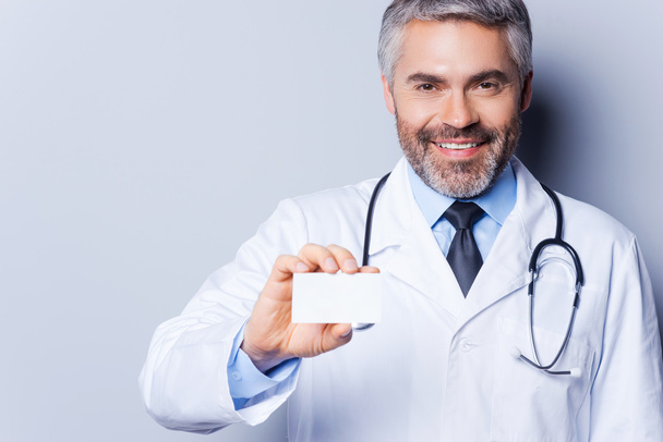 Doctor holding business card. - 写真・画像