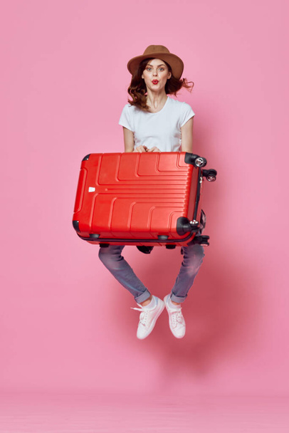 веселая женщина с чемоданом багаж путешествия развлечения розовый фон - Фото, изображение