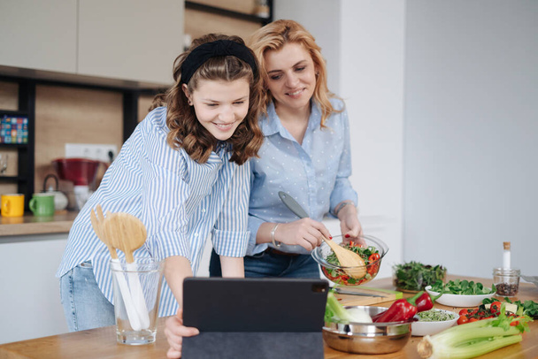 Мать и дочь подростки готовят вместе - Фото, изображение