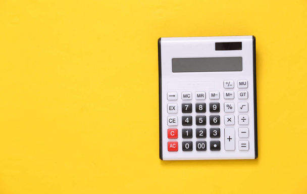 Large white calculator on yellow background - Foto, afbeelding