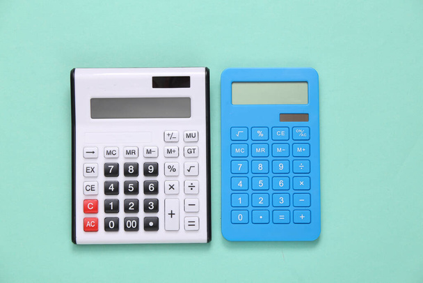 Two calculators on a blue background. Top view - Foto, afbeelding