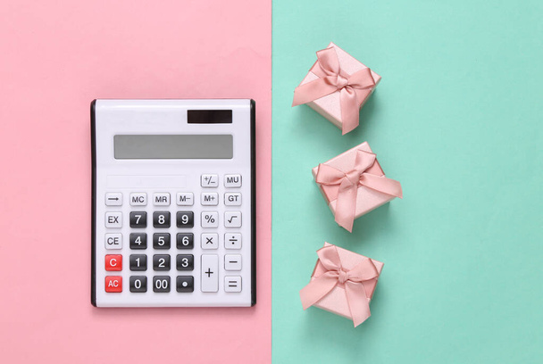 Kalkulačka s dárkovými krabicemi na růžové modré pastelové pozadí. Horní pohled - Fotografie, Obrázek