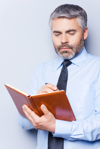 Man in shirt and tie writing in note pad - Photo, image