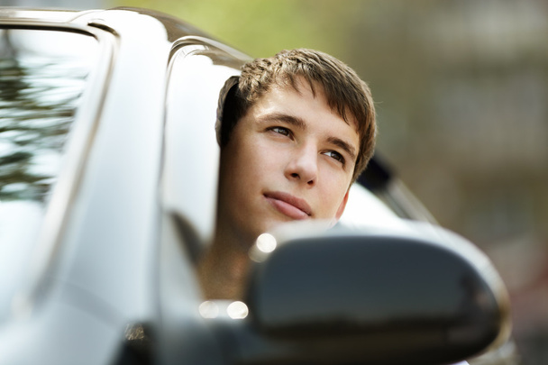 Teen driver in good mood with black car, selective focus on eyes - Φωτογραφία, εικόνα