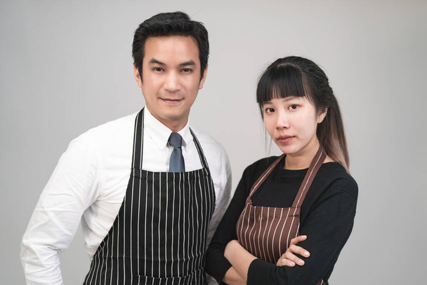 Couple asiatique entrepreneur homme et femme portant tabliers debout sur fond gris. - Photo, image
