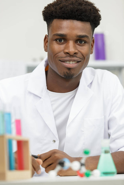handsome medical doctor in white coat is looking at camera - Foto, afbeelding