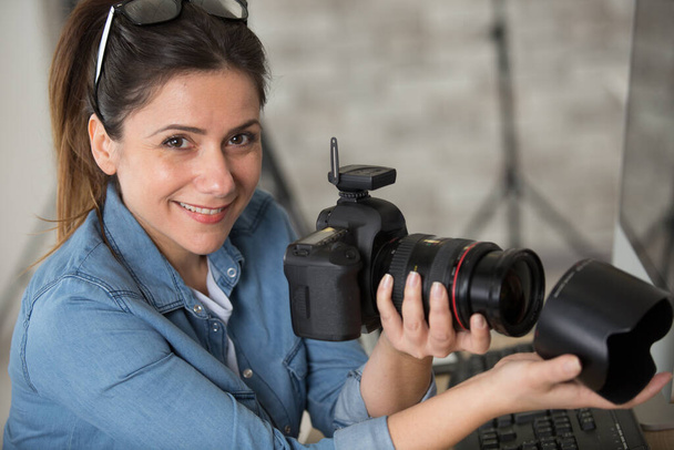 female photographer adding lens attachment to camera - Foto, Bild