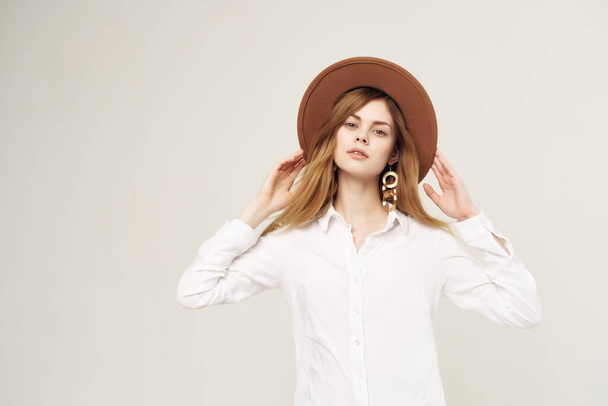 女性の白いシャツを着て帽子現代的なスタイルのポーズグラマー隔離された背景 - 写真・画像