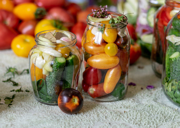 стеклянные банки различных цветов, типов, форм овощей, овощей, приготовленных для домашней консервирования, осенний сбор урожая, осень - Фото, изображение