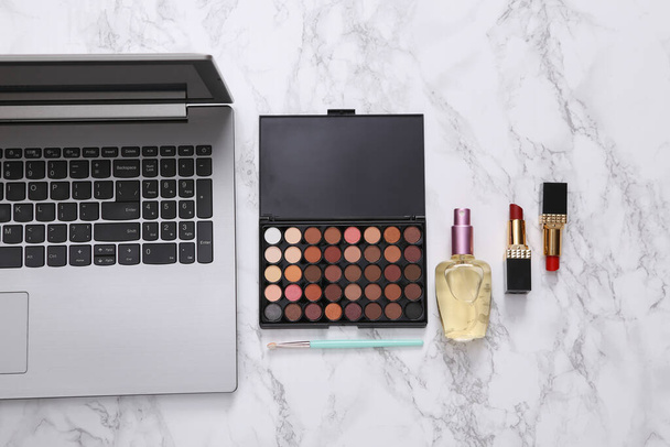 Інтернет-блог краси. Ноутбук з аксесуарами для макіяжу на мармуровій поверхні. Вид зверху
 - Фото, зображення