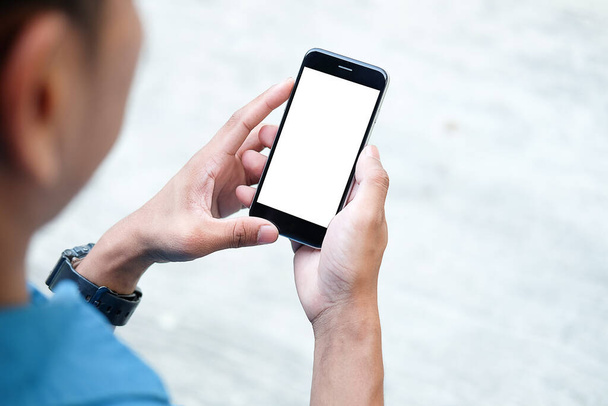 Gesneden shot weergave van de man handen houden smartphone met blanco kopieerruimte scherm voor uw sms-bericht of informatie-inhoud, vrouwelijke lezen sms-bericht op mobiele telefoon tijdens in stedelijke omgeving.  - Foto, afbeelding