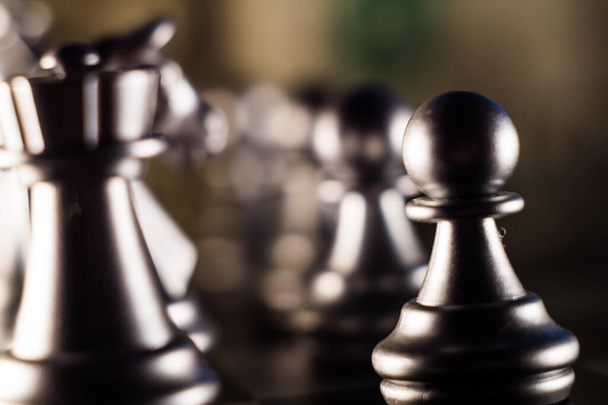 A closeup shot of silver chess pieces on a chessboard - Photo, image