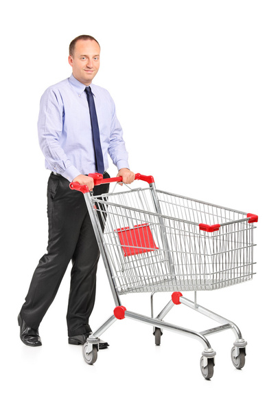 Young man pushing shopping cart - Фото, изображение