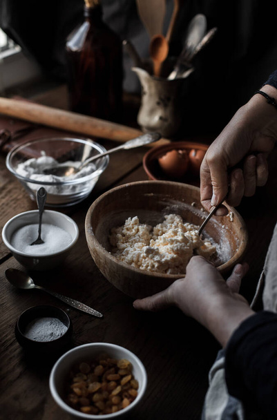 A cook baking pastry in the kitchen with different ingredients on the table - Photo, Image