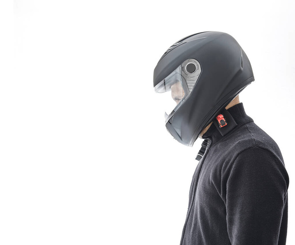 Portrait of guy with black checkered jacket and motorcycle helmet pretending to ride motorcycle, isolated on white studio wall. - Photo, Image