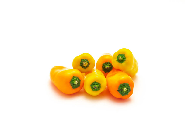 Ομάδα από ζωντανές κίτρινες και πορτοκαλί και κίτρινες μίνι γλυκές πιπεριές απομονώνονται σε λευκό φόντο. Πολύχρωμο μείγμα μικροσκοπικών μίνι σνακ πιπεριές είναι πιο γλυκιά από το μέσο όρο πιπεριά. - Φωτογραφία, εικόνα