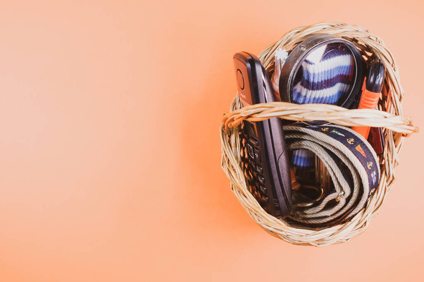 A top view of a woven basket full of Hiking tools on an orange isolated background, with free space for text - Photo, image