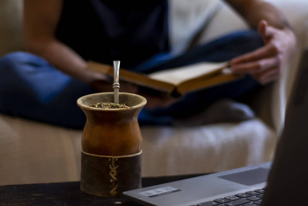 A soft focus of a serving of yerba mate drink beside a laptop - Photo, Image
