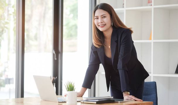 Smiling young businesswoman working with computer tablet in modern workplace. - Foto, Bild