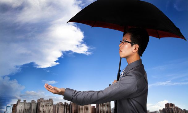 der Versicherungsvertreter mit Regenschirm und Wetterbeobachtung - Foto, Bild
