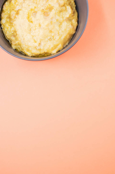 A vertical shot of scrambled omelette on a bowl isolated on an orange background - Foto, Imagem