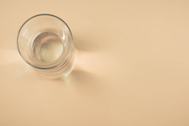 A top view of a clear glass bottle isolated on a brown background - Fotoğraf, Görsel