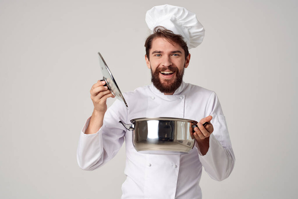 Chef masculin joyeux regardant dans la casserole préparant gastronomique - Photo, image