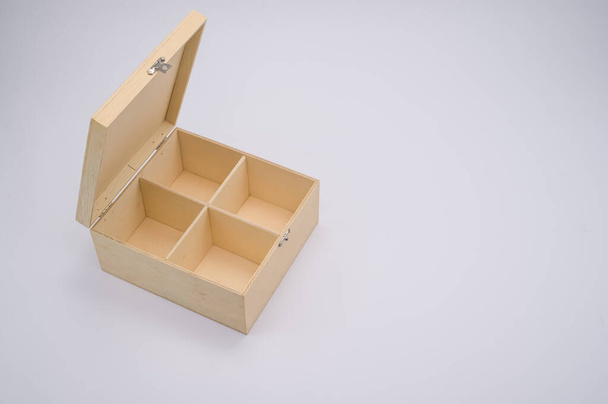 A high angle shot of open wooden box with dividers isolated on a gray background - Fotó, kép