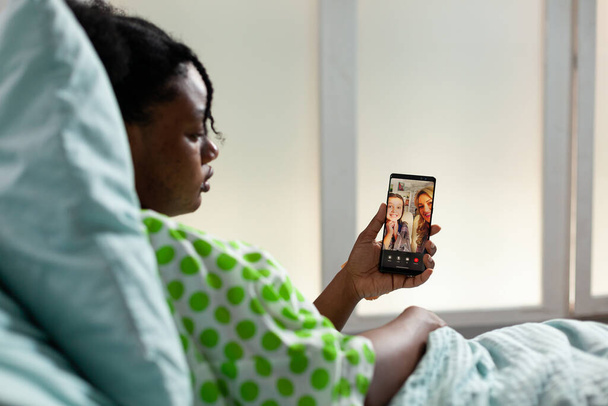 Paziente di etnia afroamericana con smartphone - Foto, immagini