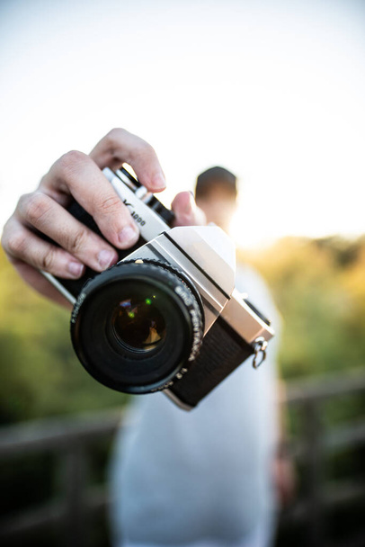 A closeup shot of a professional camera handed by an unrecognizable photographer - 写真・画像