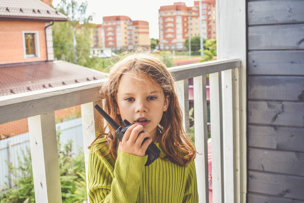 a girl child is talking on the radio on a sunny summer day - Fotoğraf, Görsel