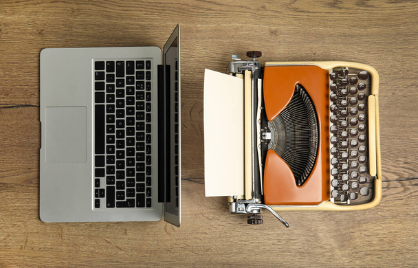 Máquina de escribir vieja y portátil en mesa de madera, puesta plana. Concepto de progreso tecnológico - Foto, imagen