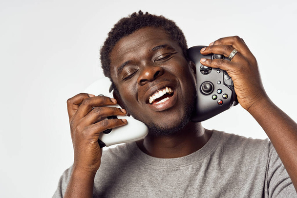 Cheerful male african-looking gamepad video games entertainment technology - Photo, Image
