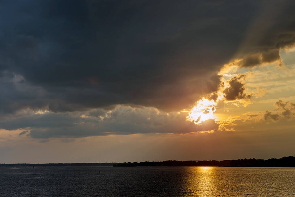 Рассвет над блестящим океаном с красивой облачностью - Фото, изображение