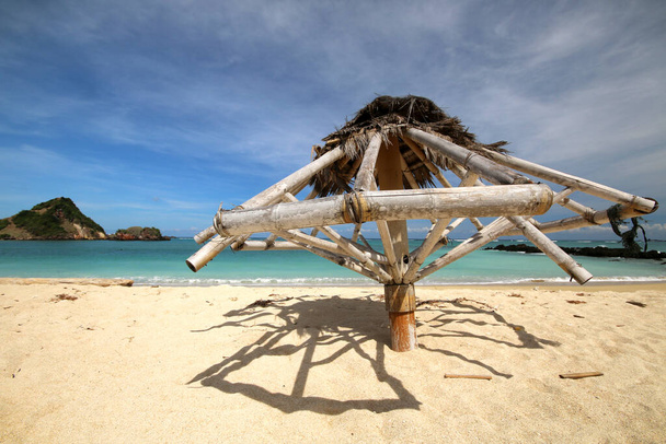 an umbrella sitting on top of a sandy beach - Photo, Image