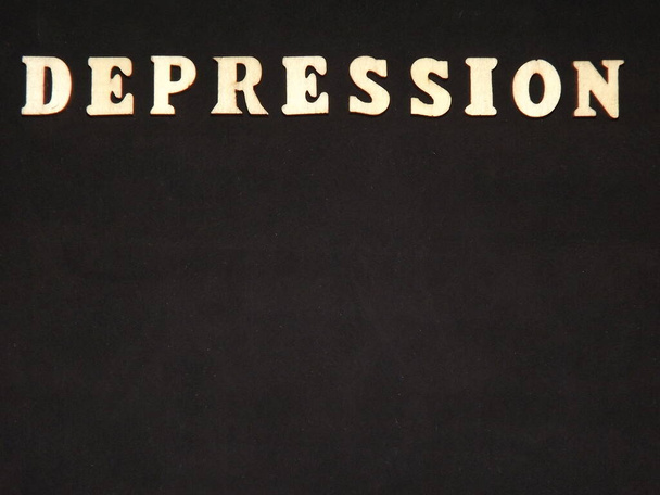 enfermedad mental depresión en letras de madera sobre un fondo negro - Foto, imagen