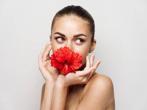 Güzel kadın çıplak omuzlar kırmızı çiçek kozmetik lüksü - Fotoğraf, Görsel