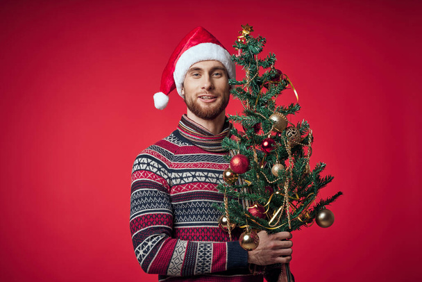 uomo in abiti di Natale albero di Natale decorazione vacanza rosso sfondo - Foto, immagini