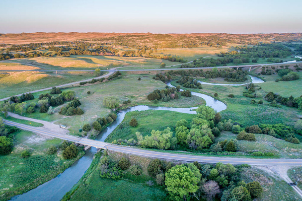 aerial view of a highway and bridges over the Dismal River in Nebraska Sandhills near Thedford, spring scenery lit by sunrise light - Foto, afbeelding
