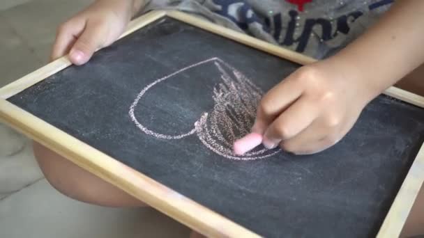 Выберите фокус рисования руки ребенка и раскраски формы любви на доске мелом - Кадры, видео