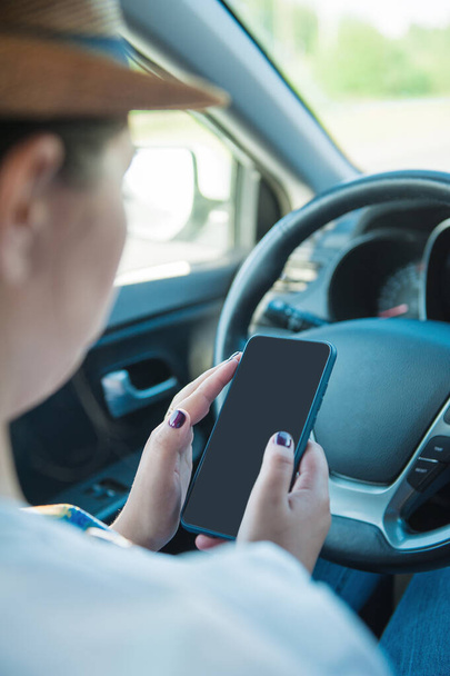 Mulher com telefone celular em mãos sentado dentro de seu carro - Foto, Imagem