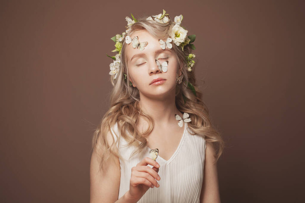 Мечтающая молодая женщина с бабочками и цветами. Мечты о любви и весне - Фото, изображение