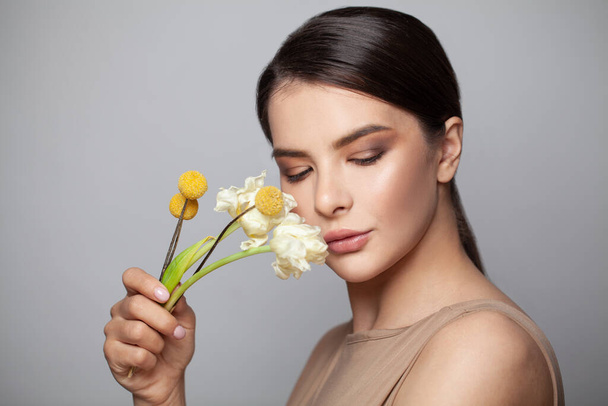 Egészséges nő tiszta bőrrel és virágokkal portré - Fotó, kép