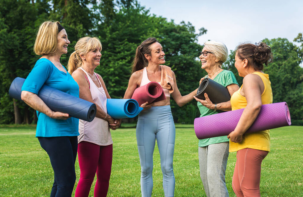 Gruppo multietnico di donne anziane che si allenano al parco con istruttore di fitness - Anziani attivi che praticano sport nella natura - Foto, immagini